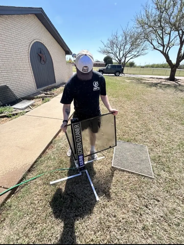Window screen being washed on a screen cleaning stand